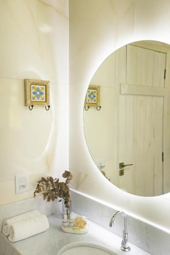a bathroom with a round mirror and a sink at Pousada Altoé da Montanha in Venda Nova do Imigrante