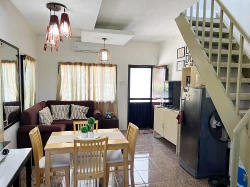 a kitchen and living room with a table and a couch at Beach Resorts walking distance to the Town House in Davao City