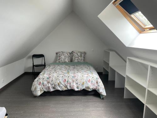 une chambre avec un lit dans un grenier dans l'établissement Gîte du Cerisier, à Liesville-sur-Douve