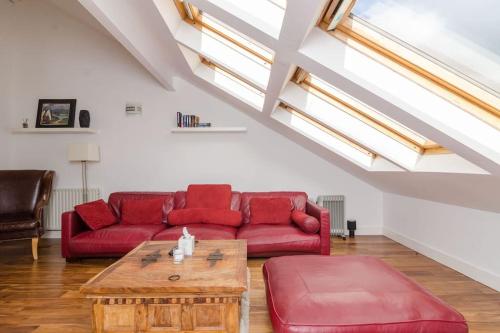 a living room with a red couch and a coffee table at 4 stars Rating Tourist board certified Spacious penthouse Apartment in Belfast