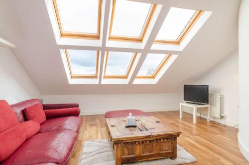a living room with a red couch and a table at 4 stars Rating Tourist board certified Spacious penthouse Apartment in Belfast