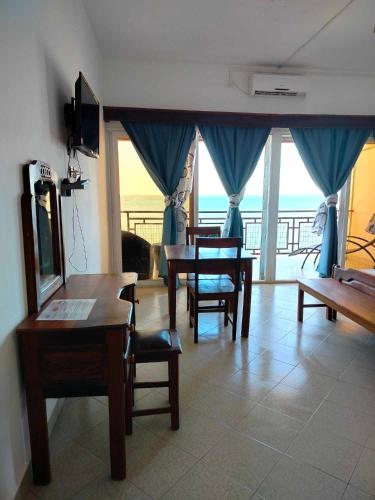 a living room with tables and chairs and a balcony at Annexe RAOOF HOTEL in Mahajanga
