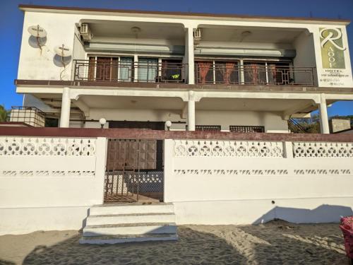a white building with a balcony and stairs at Annexe RAOOF HOTEL in Mahajanga