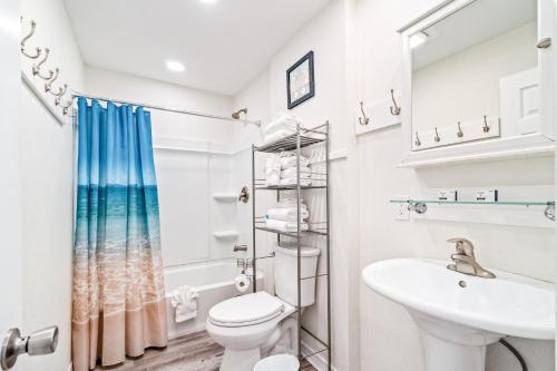 a white bathroom with a toilet and a sink at Moonraker 25 in Gulf Shores