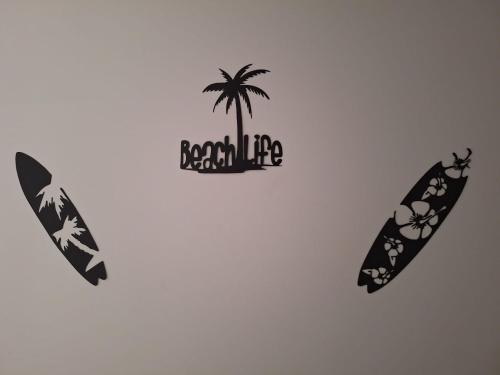 two surfboards with the words beach life and a palm tree at Sunny Waves in Northampton