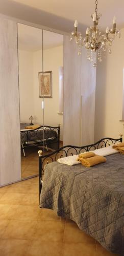 a bedroom with a bed and a chandelier at La Casa di Oli&Cris in Bolsena