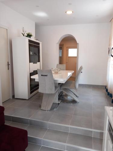 a dining room with a white table and chairs at Les Jardins Secrets in Romilly-sur-Seine