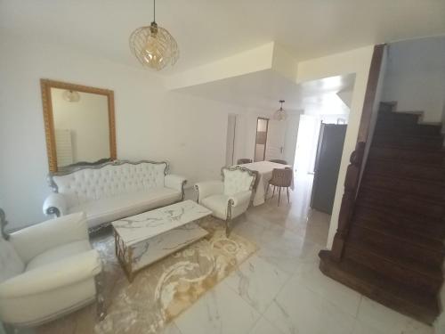 a living room with white furniture and a mirror at Les Jardins Secrets in Romilly-sur-Seine