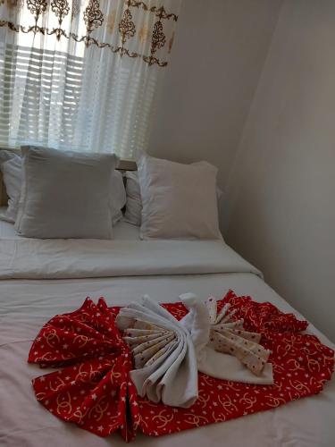 a white bed with a red flower on it at Les Jardins Secrets in Romilly-sur-Seine