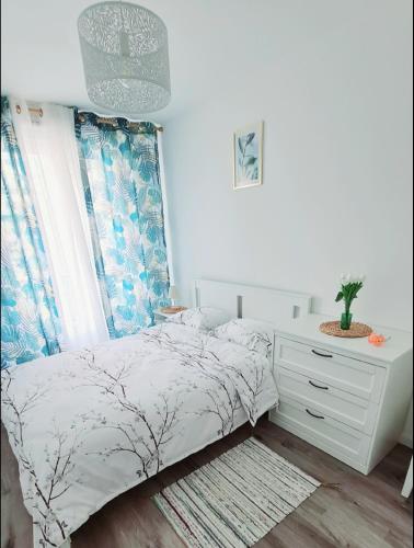 une chambre blanche avec un lit et une commode dans l'établissement Chic Central, 10 Min from Paris, à Argenteuil