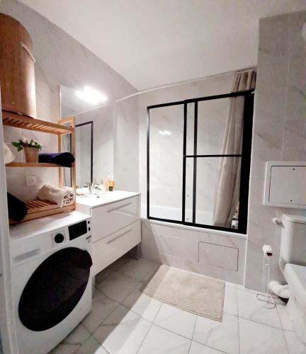 une salle de bain blanche avec un lavabo et une fenêtre dans l'établissement Chic Central, 10 Min from Paris, à Argenteuil