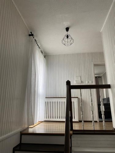a room with a staircase with a window and a chair at Apartament M6 w Centrum Wiela in Wiele