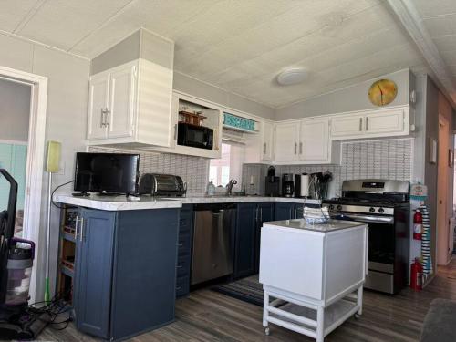a kitchen with white cabinets and a blue counter top at Venice Bungalow in Venice