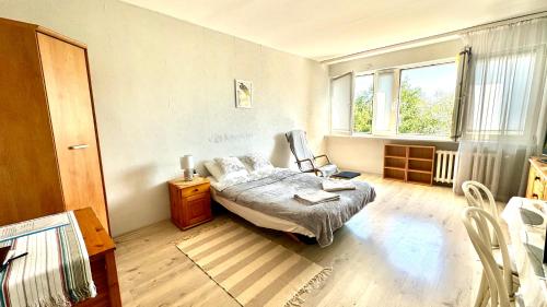 Un dormitorio con una cama y una mesa y una ventana. en Sady Żoliborskie, en Varsovia