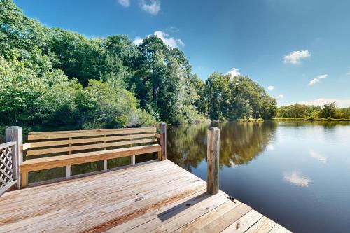 a wooden bench sitting on a dock on a lake at Healing Adventures in Claxton
