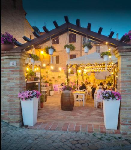 a patio with tables and flowers in a building at Albergo Diffuso Borgo Montemaggiore in Montemaggiore al Metauro