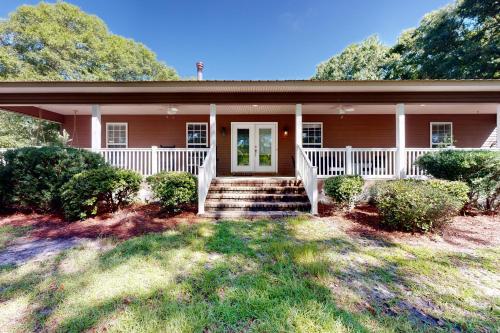 a house with a porch and stairs in front of it at Healing Adventures in Claxton