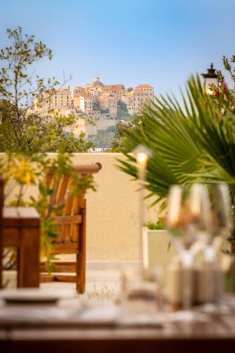 a table with a view of a city in the background at Hotel Corsica & Spa Serena in Calvi