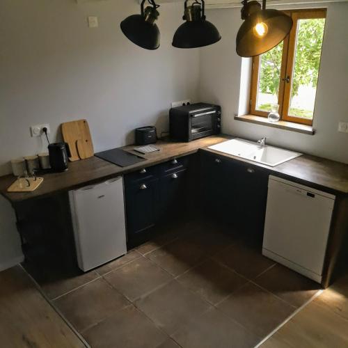 La cuisine est équipée d'un comptoir, d'un évier et d'un évier. dans l'établissement Serenity Belle France Gite, à Vieux-Ruffec