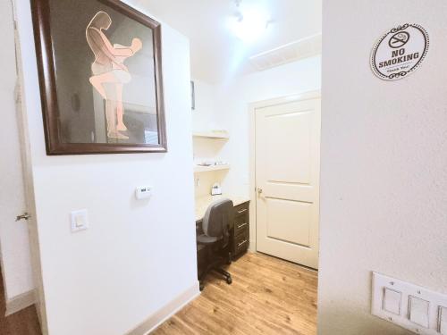 a hallway with a painting of a woman on the wall at Belle Maison near Medical Center NRG Stadium in Houston