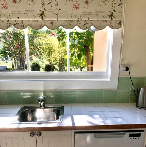 a kitchen with a sink and a window at Maple Hill Cottage in Castle Forbes Bay
