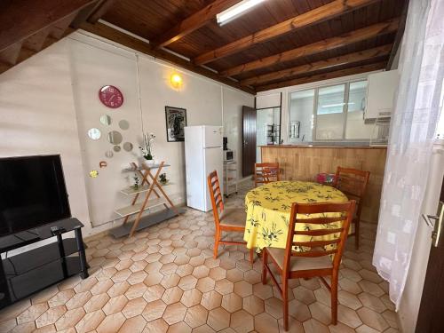 a kitchen with a table and chairs and a refrigerator at Vivalavida Duplex in Les Abymes