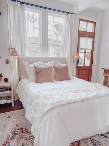 a bedroom with a large white bed with pillows at Guesthouse on Girod in Mandeville
