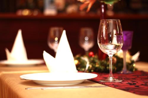 a table with two wine glasses and a christmas centerpiece at Pensjonat Korona in Modrzyca