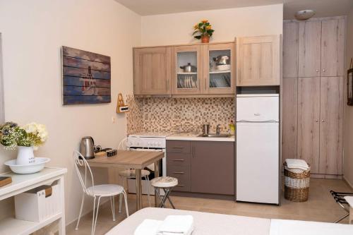 a kitchen with a white refrigerator and a table at Melograno Apartments and Studios in Kala Nera