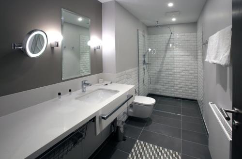 ein Badezimmer mit einem Waschbecken, einem WC und einem Spiegel in der Unterkunft Hotel am Fischmarkt in Rheinberg