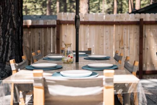 a wooden table with chairs and plates on it at Troubadour's Landing in Kings Beach