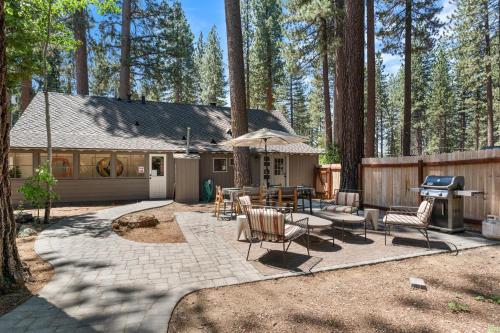 a backyard with a grill and chairs and a table at Troubadour's Landing in Kings Beach