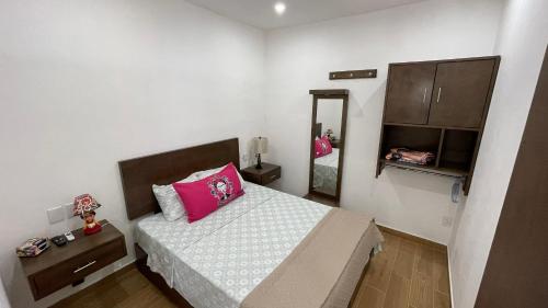 a small bedroom with a bed with a pink pillow at Frida Kahlo in Bucerías