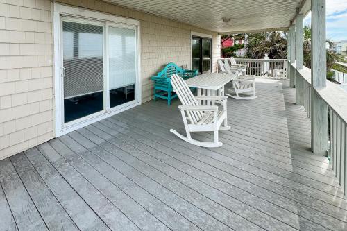 a wooden porch with a table and chairs on it at No Regrets Down in Emerald Isle