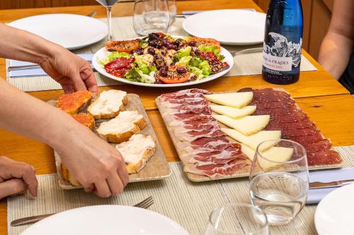 a table with a plate of food and a plate of meat and cheese at XULOS Rooms & Suites in Peñíscola