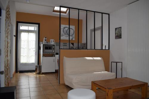 Cette chambre comprend un lit, une table et une cuisine. dans l'établissement Le Cardoué, gíte au cœur du bocage vendéen proche Puy duFou, à Chantonnay