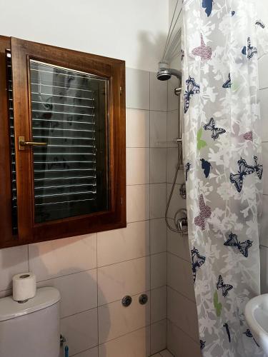 a bathroom with a shower curtain with butterflies on it at Guesthouse Ale&Ale in Tale