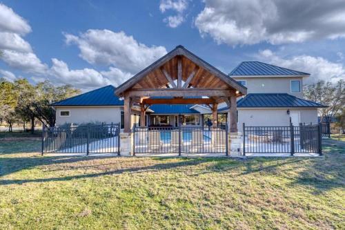 a large white house with a gate and a fence at Double Shotz in Concan