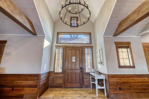 a large room with a wooden door and a chandelier at Double Shotz in Concan