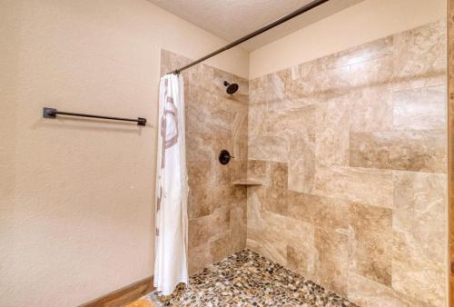 a bathroom with a shower with a stone wall at Happy Hour in Concan