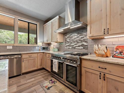 a kitchen with wooden cabinets and stainless steel appliances at She's Like Texas in Concan