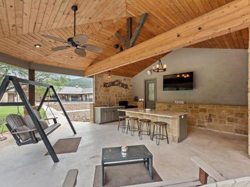 an outdoor kitchen with a ceiling fan and a table at She's Like Texas in Concan