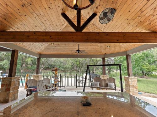 a pavilion with a table and chairs and a clock at She's Like Texas in Concan