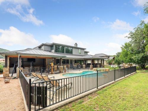 a house with a swimming pool and a fence at She's Like Texas in Concan