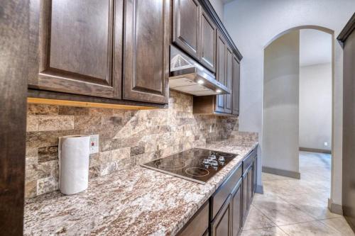 a kitchen with wooden cabinets and a stove top oven at Driftwood in Concan