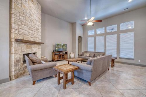 a living room with two couches and a stone fireplace at Driftwood in Concan