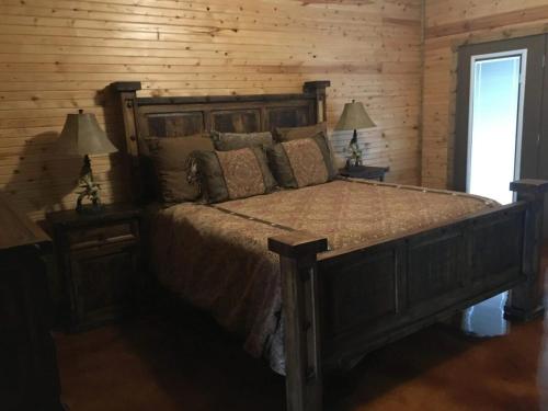 a bedroom with a large wooden bed with two lamps at Tatanka in Concan
