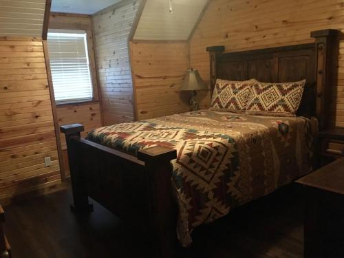 a bedroom with a bed in a log cabin at Tatanka in Concan