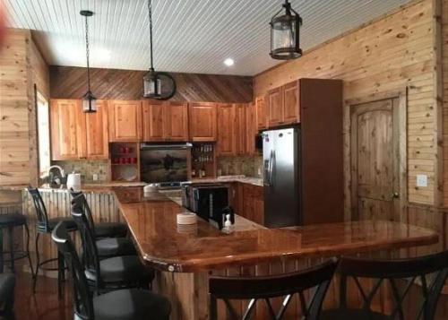 a kitchen with a large wooden island with a refrigerator at Tatanka in Concan