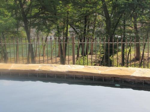 a fence next to a body of water with trees at Ryder's Ridge in Concan